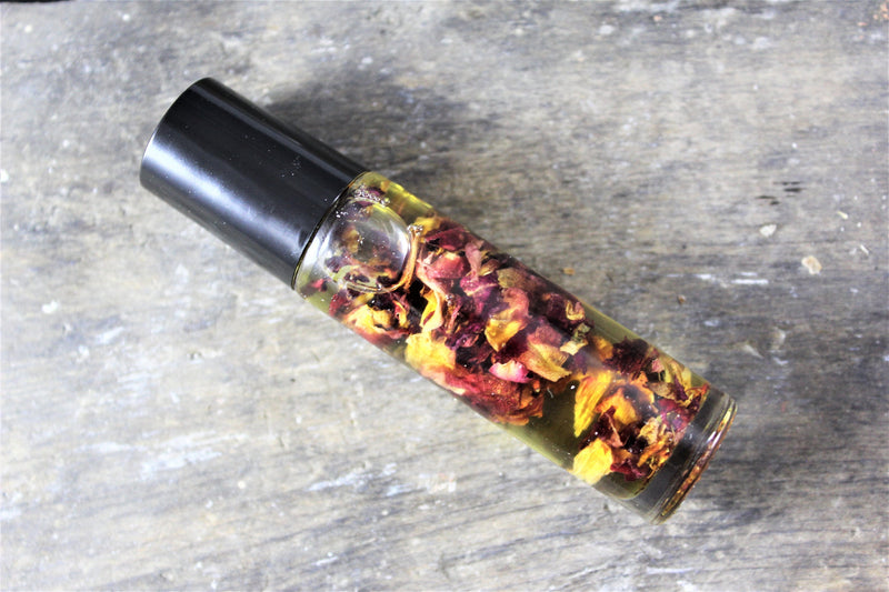 Organic perfume oil in glass bottle with rose petals, non-toxic and eco-friendly.