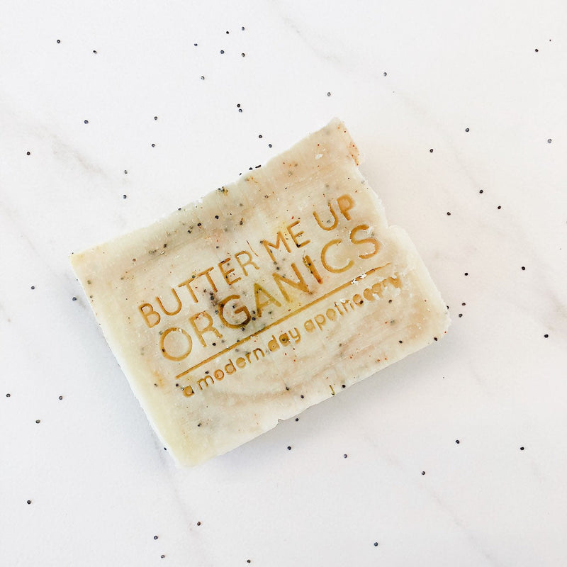 Vegan lemon poppyseed soap bar, palm-free and exfoliating, displayed on a white surface.