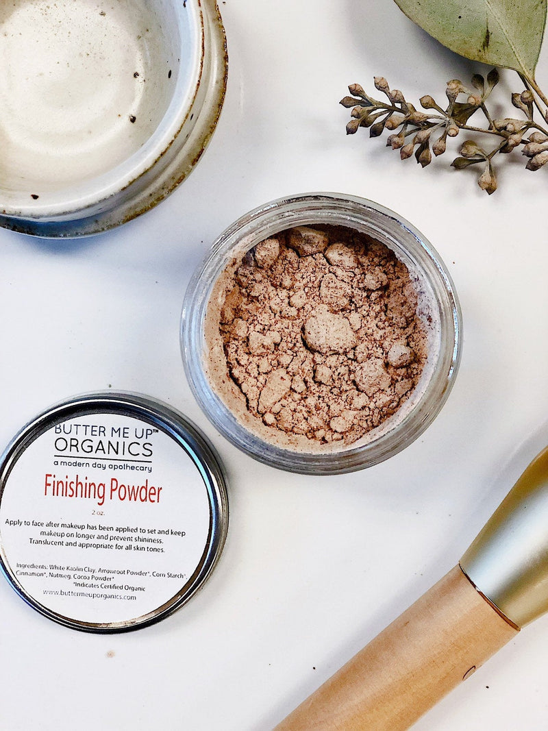 Organic finishing powder in a glass jar with metal lid, featuring natural ingredients, eco-friendly packaging, and cruelty-free formulation.