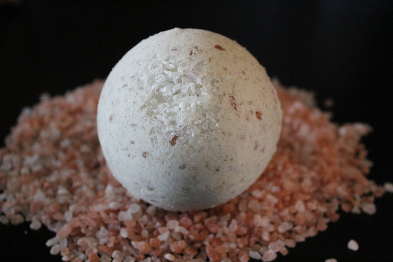 Large organic bath bomb for psoriasis and eczema relief with natural ingredients like coconut and kukui nut oil on pink salt.
