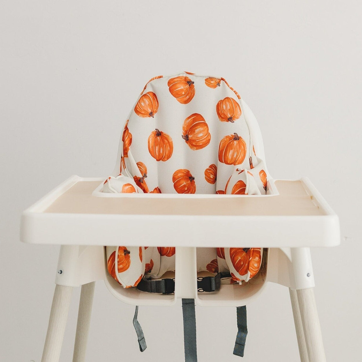 IKEA Antilop highchair cushion cover in a pumpkin print on light polyester canvas fabric.