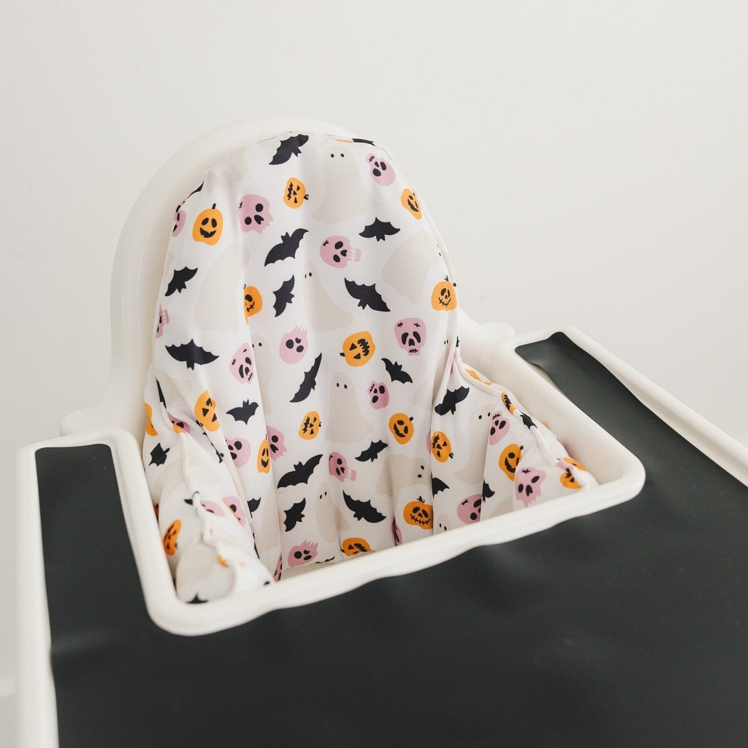 Halloween-print cushion cover fitted on an IKEA Antilop highchair seat