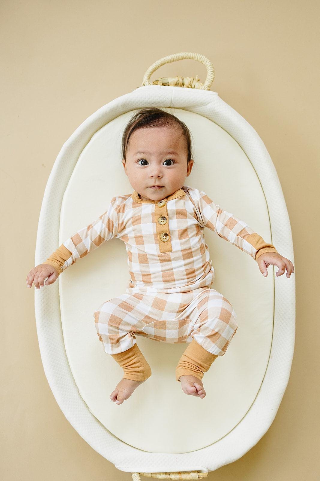 Two-piece henley baby pajama set in golden gingham print with buttoned top and matching pants