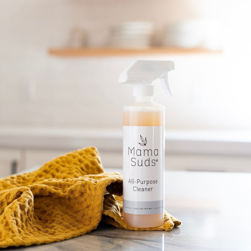 MamaSuds All-Purpose Cleaner Spray bottle on kitchen countertop with a yellow cloth.
