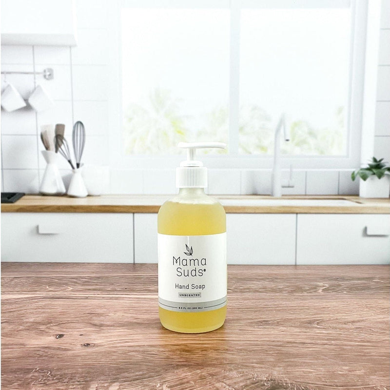Glass bottle of MamaSuds Hand Soap on kitchen countertop.