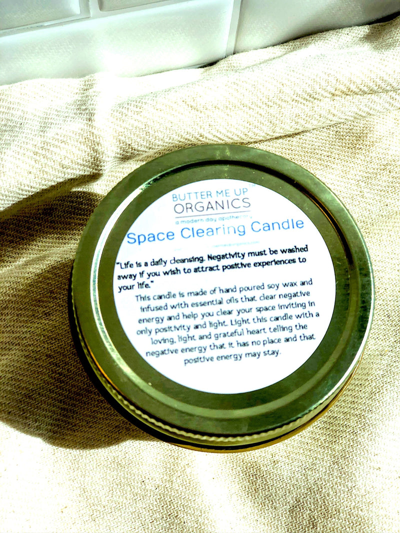 Organic space clearing candle in a jar with label for Butter Me Up Organics, designed to cleanse energy and create positive vibes.
