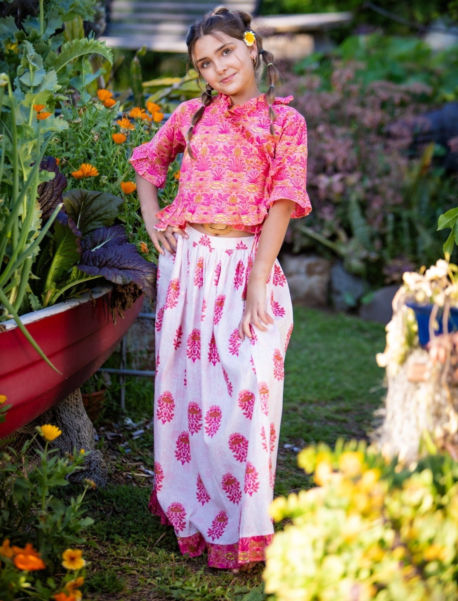 Pink cotton girls lehenga set with colorful design, wraparound 3/4-sleeve top, and matching skirt.