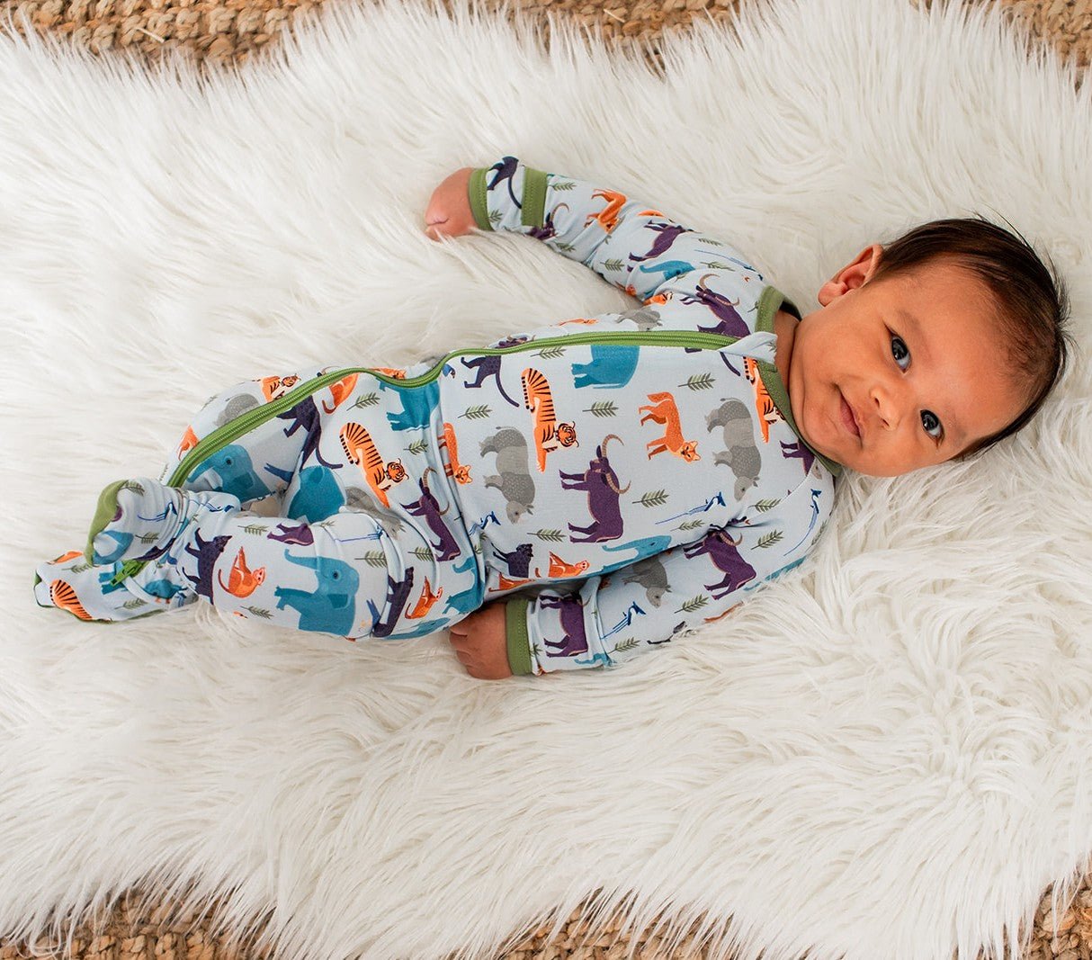 Baby footie pajamas in a safari animal print with a full-length two-way zipper and footed legs.