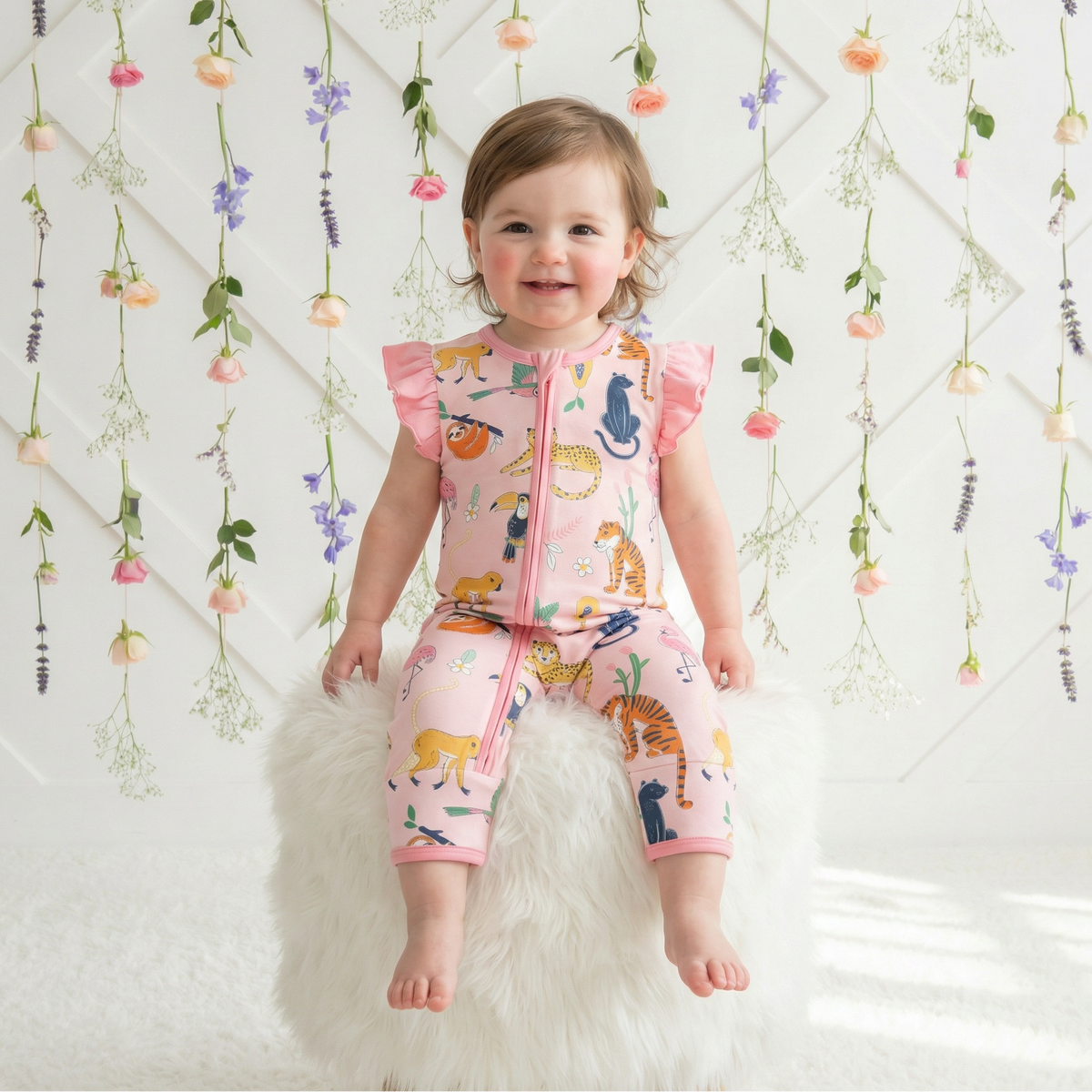 Baby coverall with long sleeves, covered feet and a front two-way zipper in a whimsical jungle animal print
