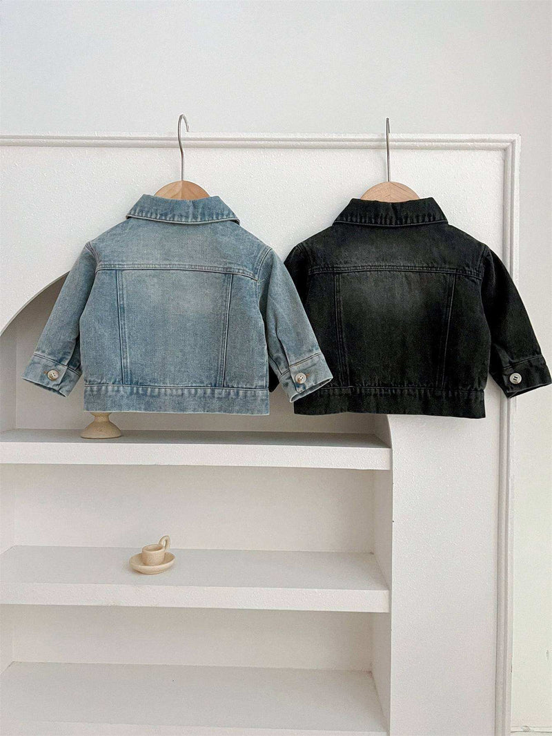 Kids button front washed style denim jacket with turned-down collar hanging on display.