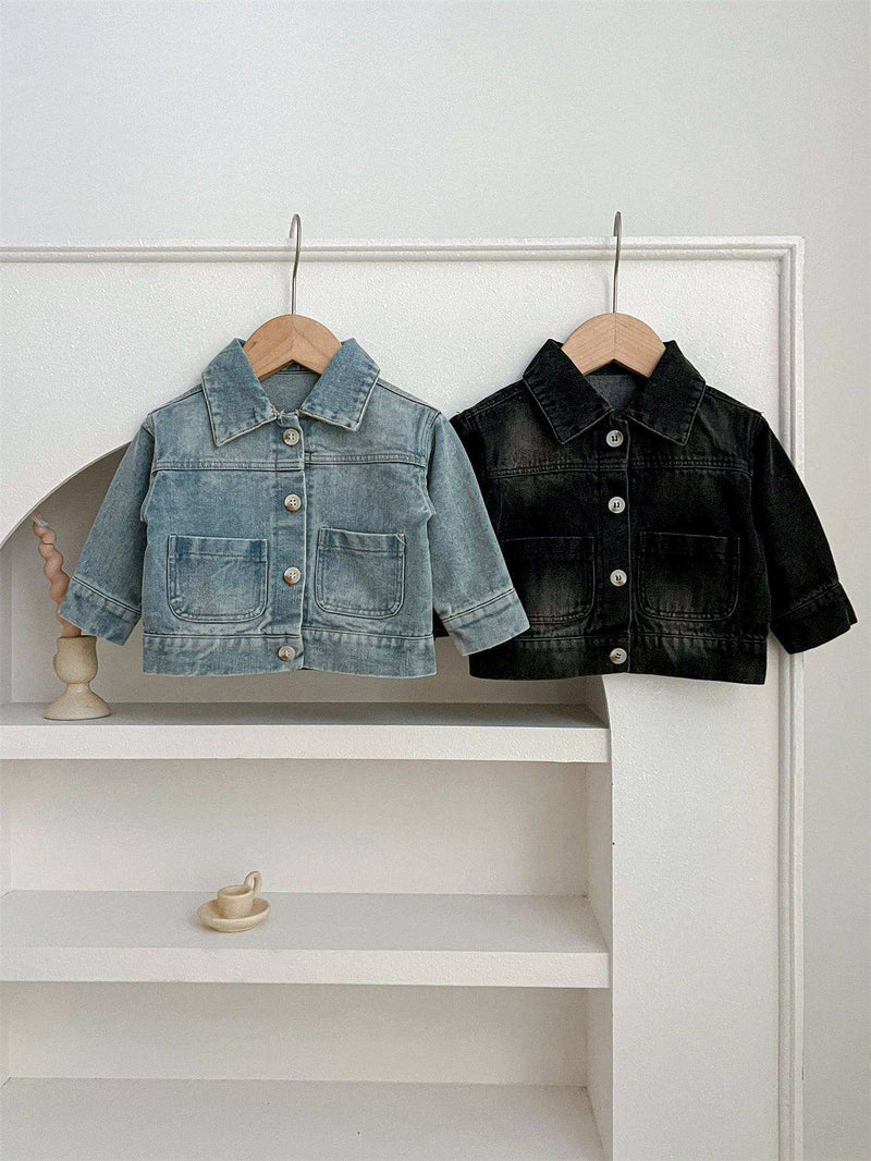 Kids button front washed style denim jackets hanging on hooks.