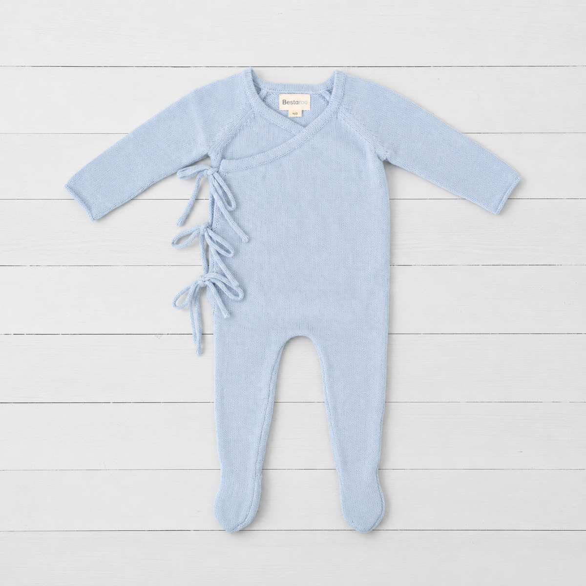 Powder blue knit baby romper with wrap front, side ties, long sleeves and built-in feet