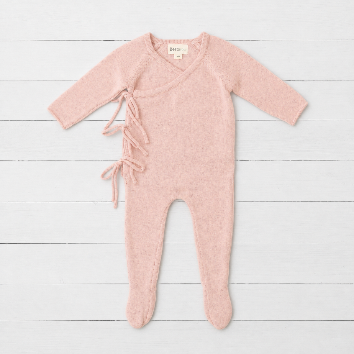 Tea rose pink knit baby romper with wrap front, side tie closure, long sleeves and built-in feet
