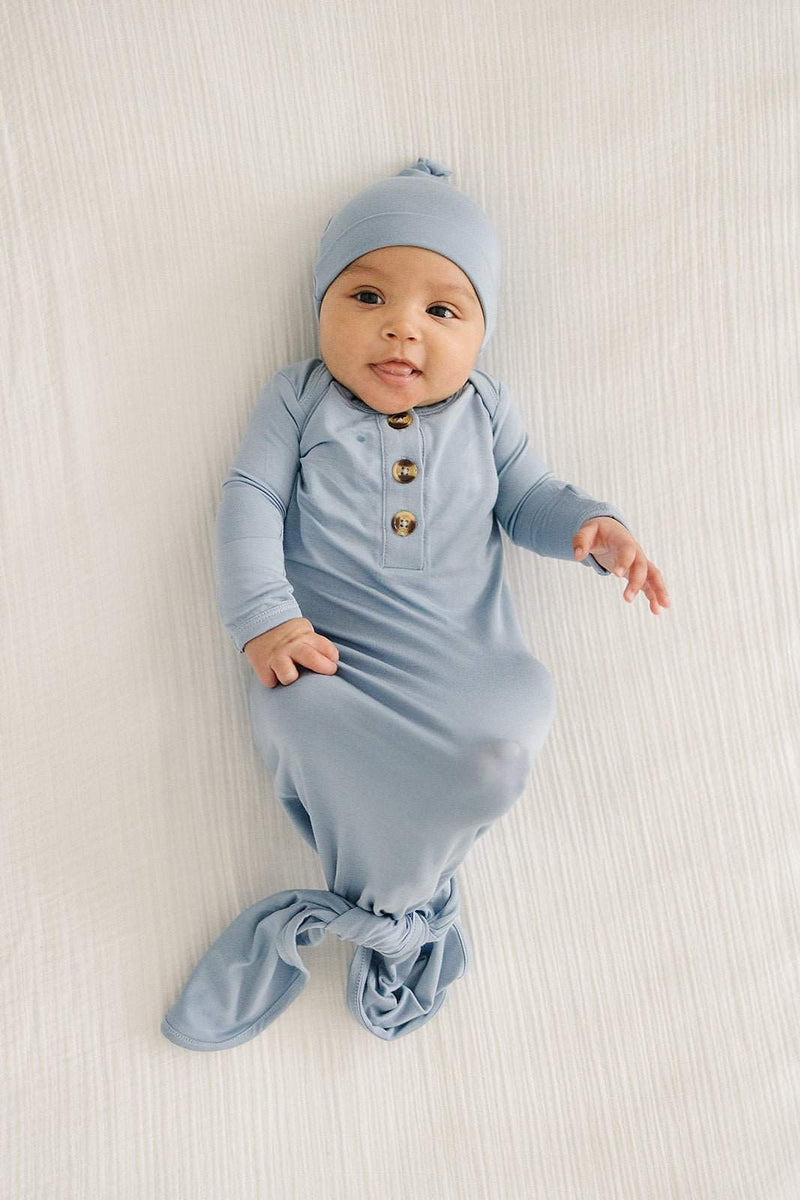 Knot hat in dusty blue on baby wearing matching outfit, suitable for newborns up to 3 months.