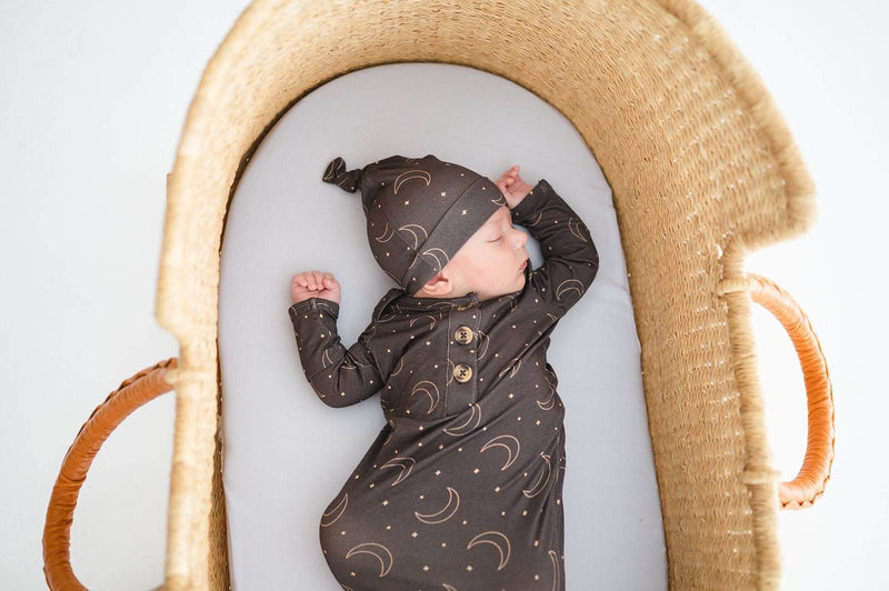 Newborn wearing a comfortable knot hat with a midnight moon design, perfect for warmth and style.