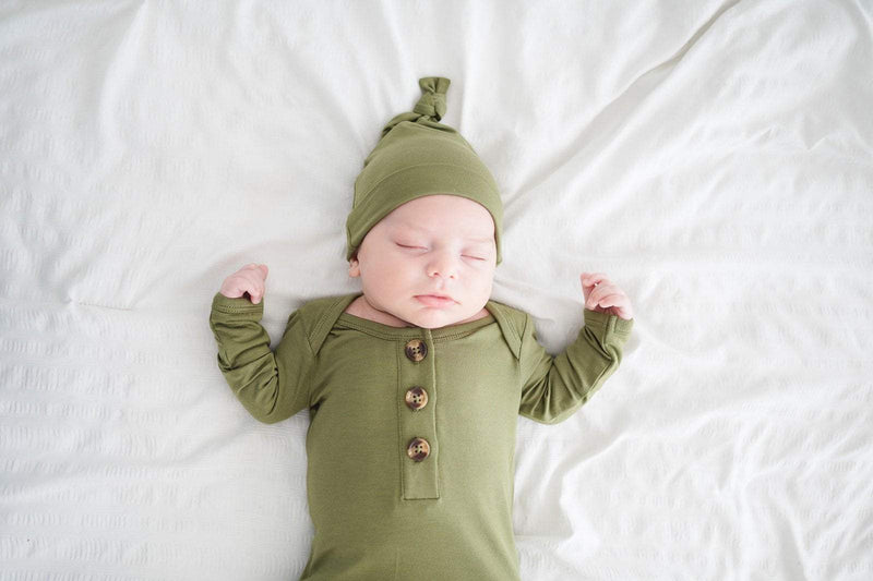 Olive green knot hat on sleeping newborn.