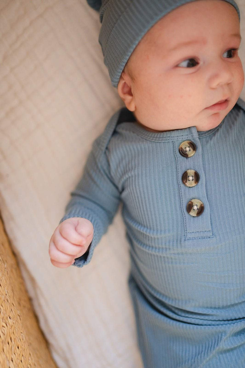 Knotted baby gown in Arona Blue ribbed fabric with button details, perfect for newborns.
