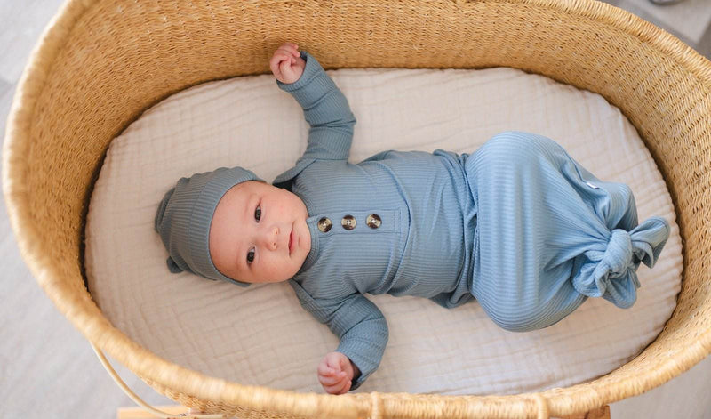Knotted baby gown in Arona blue ribbed fabric with a matching hat, made from soft bamboo viscose, suitable for newborns up to 3 months.