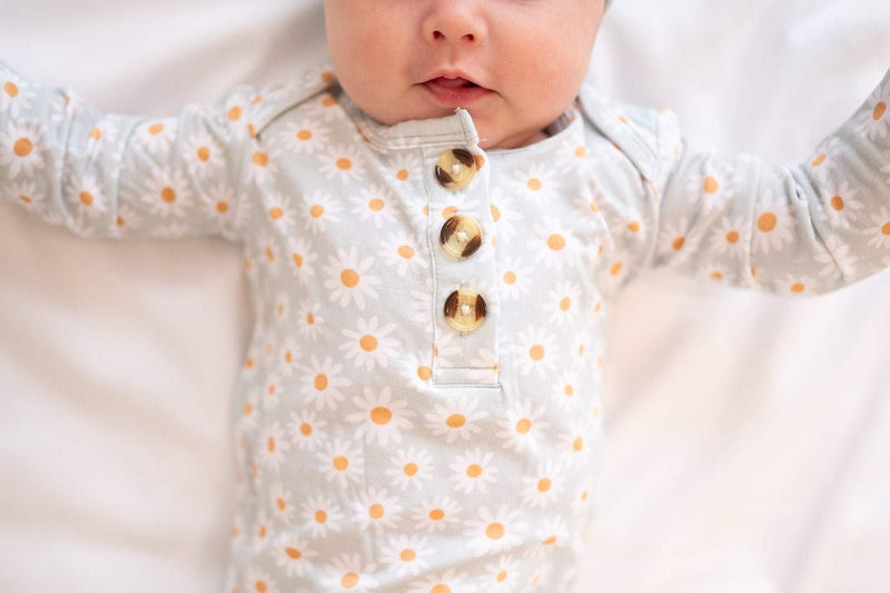 Blue daisy knotted baby gown with fold-over cuffs for easy diaper changes.