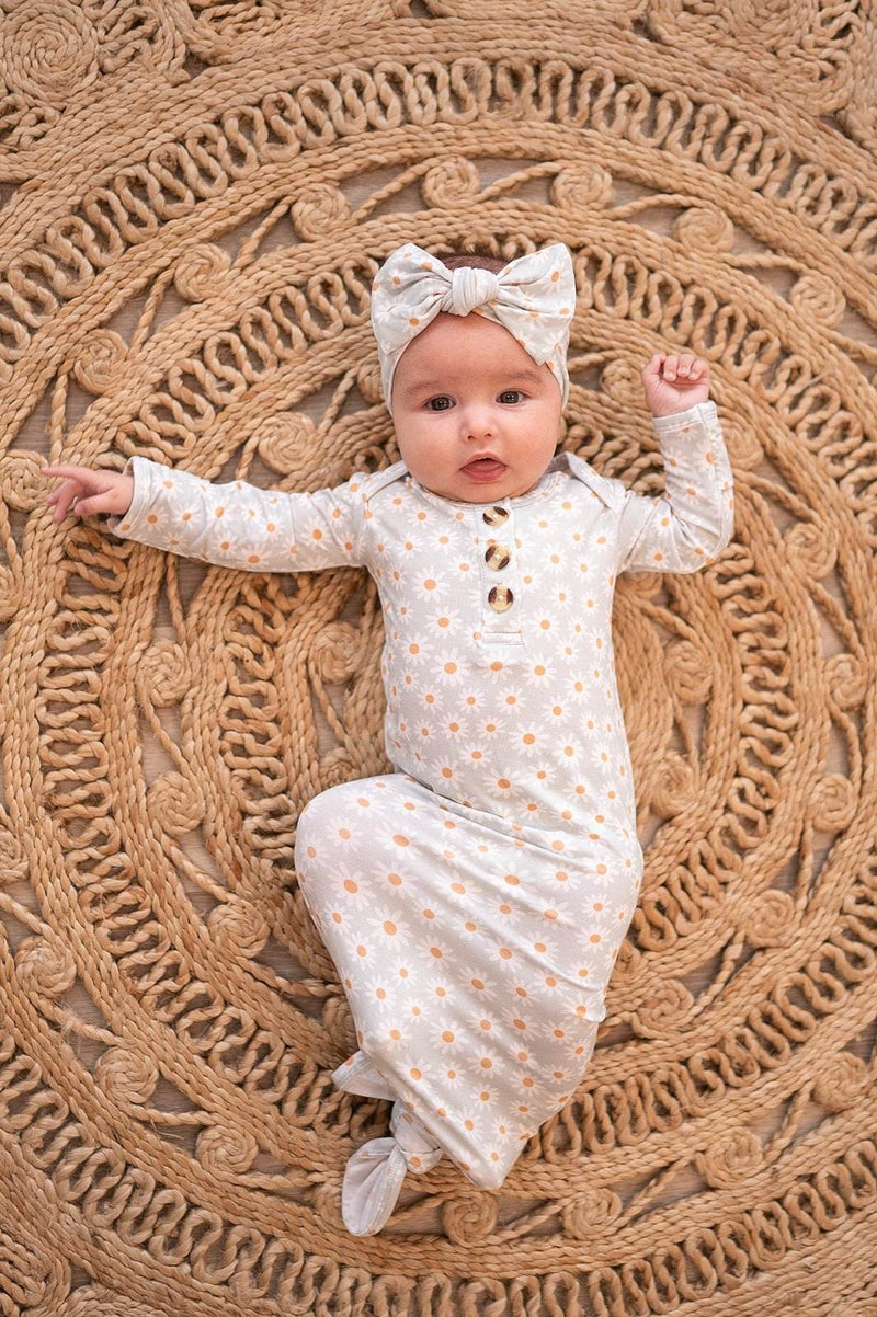 Knotted baby gown with blue daisy pattern featuring fold-over cuffs, ideal for 0-3 months.