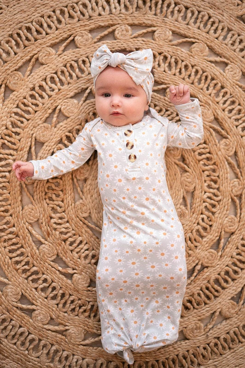 Knotted baby gown with blue daisy pattern and fold-over cuffs for 0-3 months.