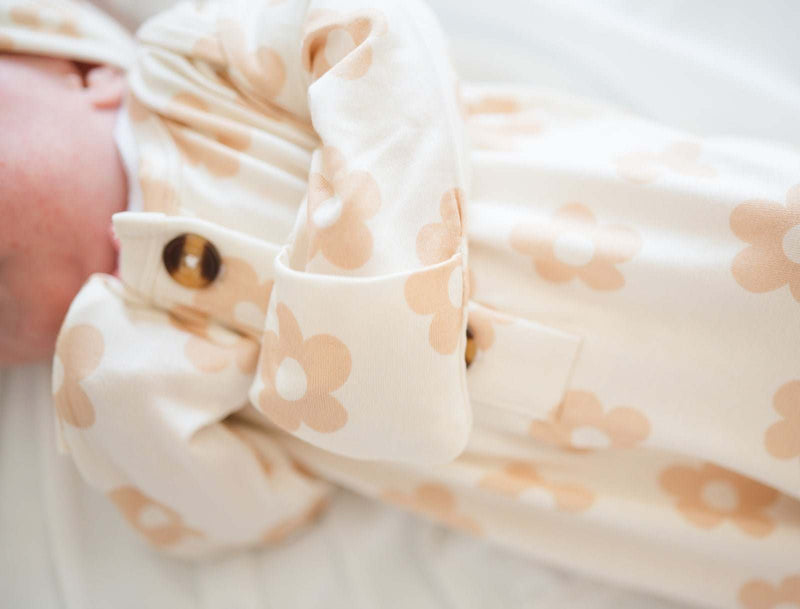 Knotted Baby Gown in Blush Daisy pattern with bamboo viscose material, featuring fold-over cuffs.