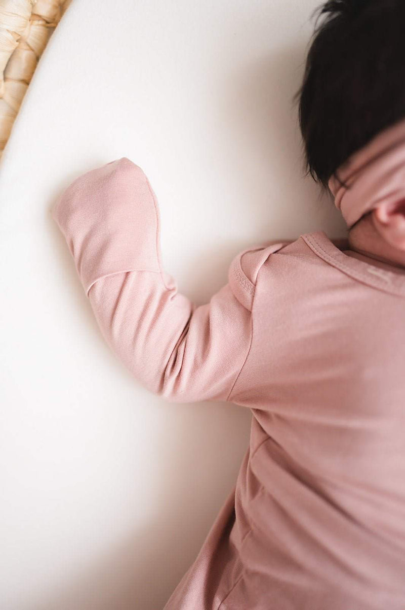 Dusty pink knotted baby gown with fold-over cuffs made from soft bamboo material.