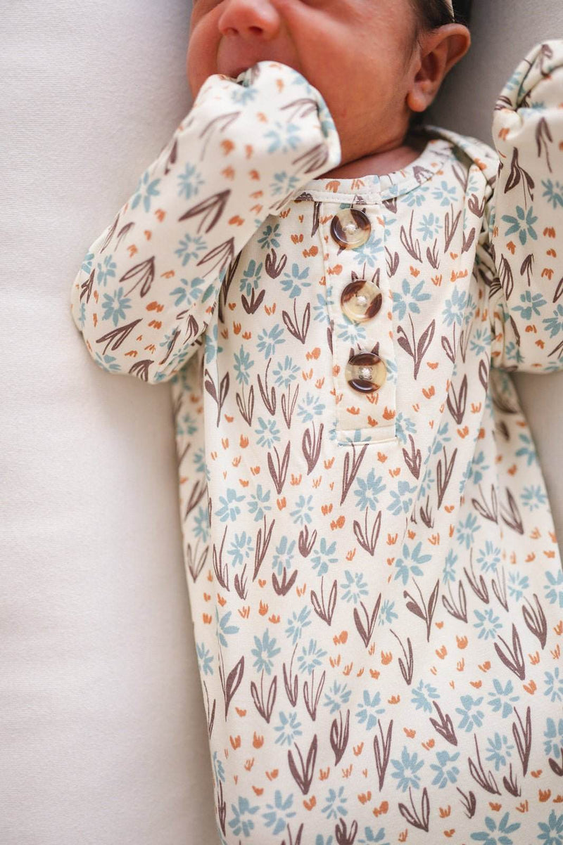 Knotted baby gown with la la floral pattern made from soft bamboo viscose, featuring fold-over cuffs for infants 0-3 months.