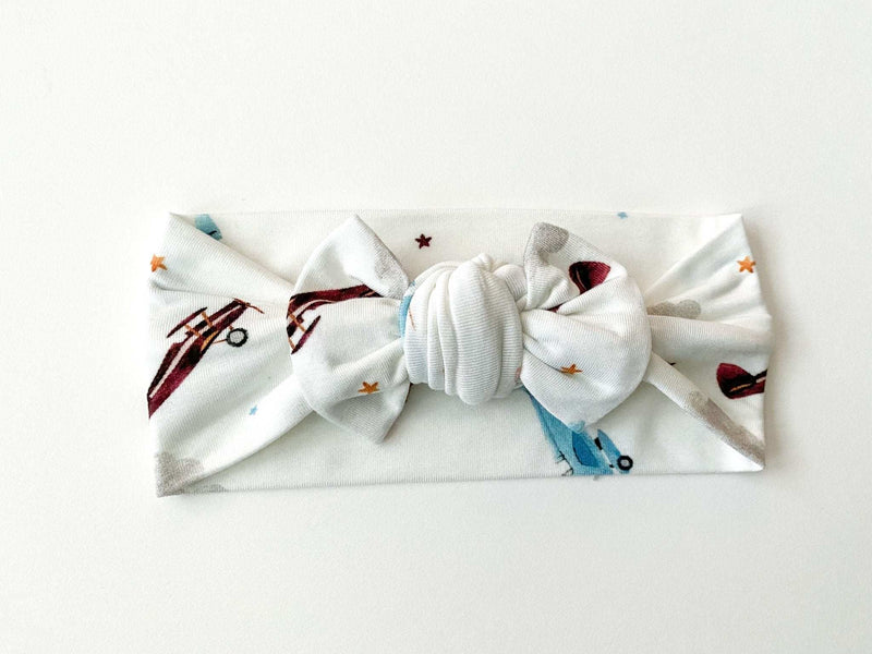 Knotted baby gown with vintage airplane design on soft bamboo viscose fabric, perfect for newborns.