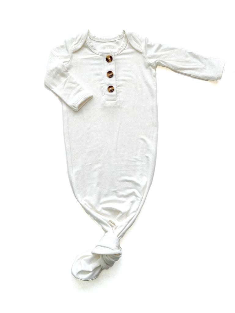 White knotted baby gown made from bamboo viscose, featuring fold-over cuffs and a knotted bottom for easy diaper changes, size 0-3 months.