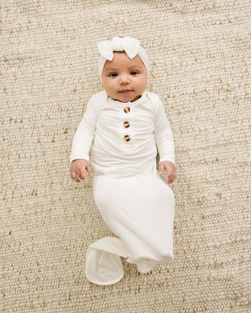 White knotted baby gown made of soft bamboo viscose with fold-over cuffs, ideal for 0-3 months.