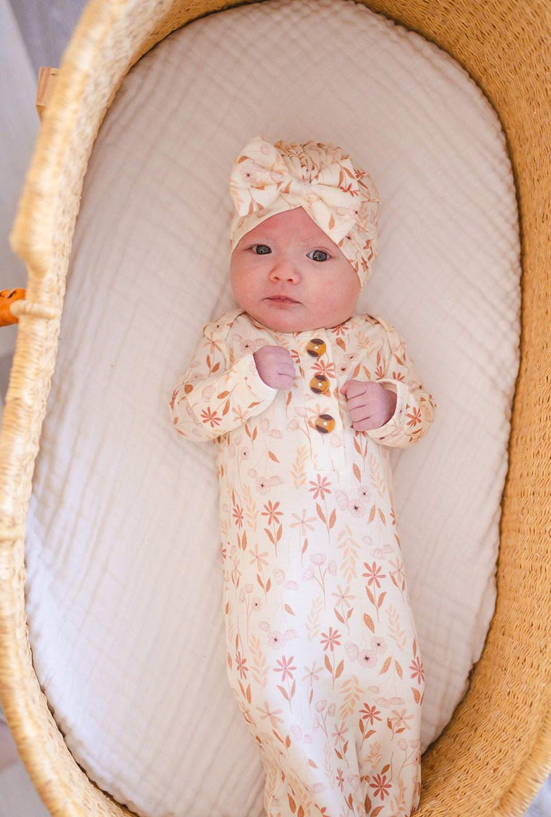 Knotted baby gown with wildflower print in soft bamboo viscose, featuring fold-over cuffs and knotted bottom for easy diaper changes.