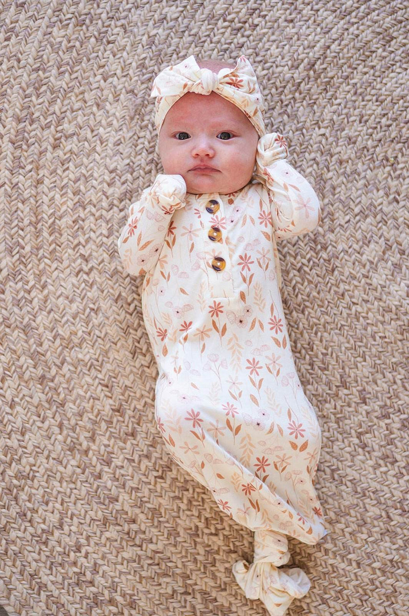 Knotted baby gown with wildflower pattern and knotted bottom for easy diaper changes.