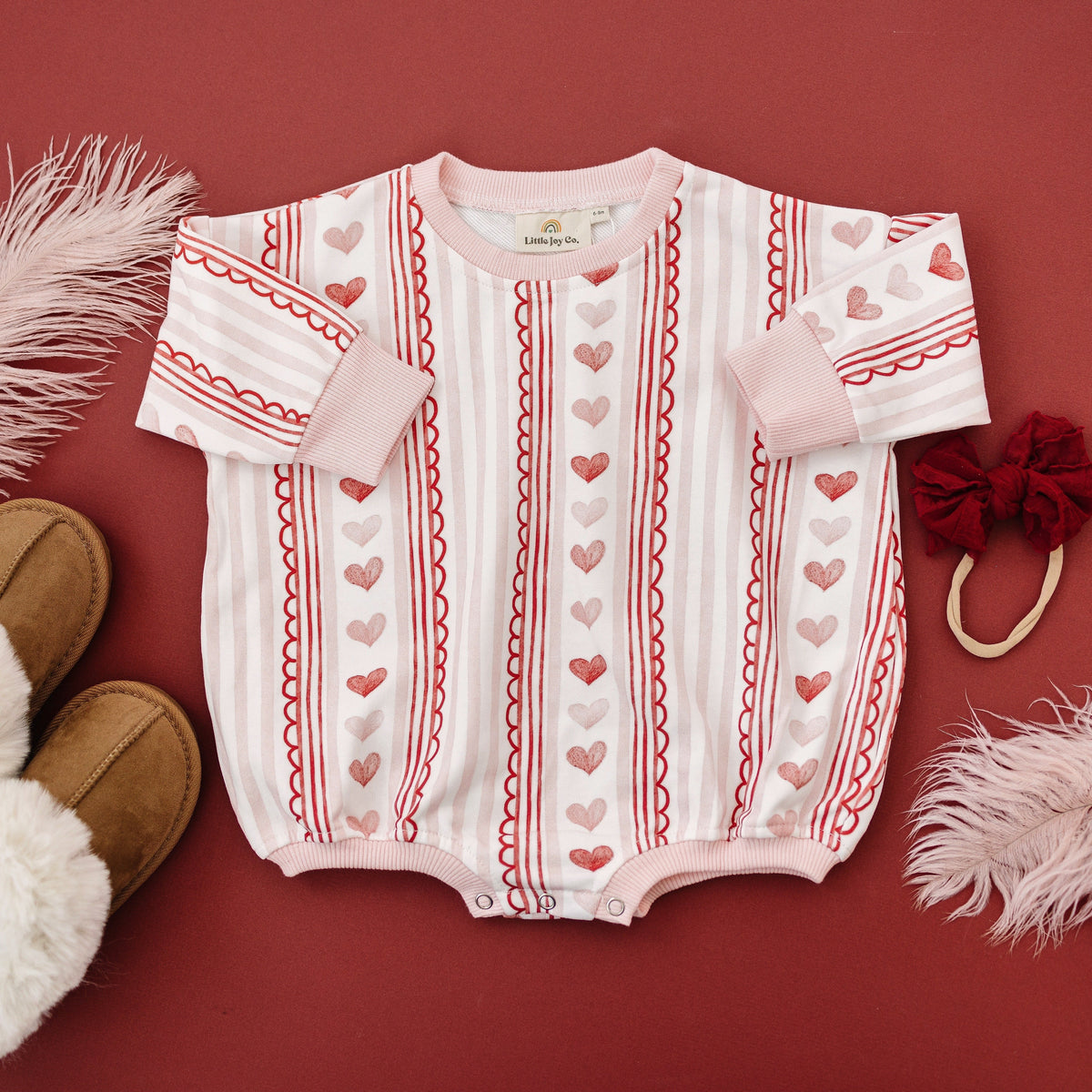 Baby wearing Laced with Love organic cotton sweatshirt romper with lace trim detail, smiling.