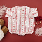 Baby wearing Laced with Love organic cotton sweatshirt romper with lace trim detail, smiling.