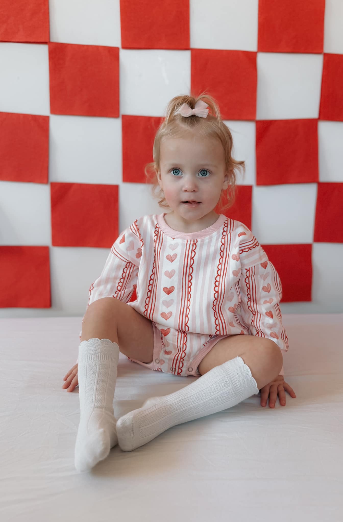 Baby wearing Laced with Love organic cotton sweatshirt romper with lace trim detail, smiling.