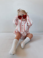 Baby wearing Laced with Love organic cotton sweatshirt romper with lace trim detail, smiling.