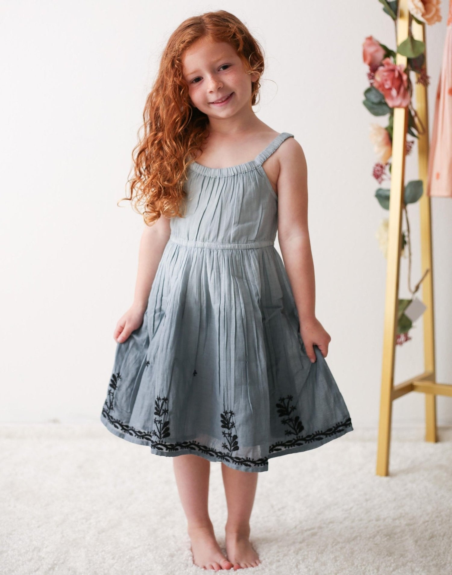 Baby girl dress in grey with a lightly ombre look, modern neckline, and embroidered detail along the hem