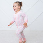 Baby convertible coverall in abstract pink cloud print with a full-length two-way zipper and fold-over feet.
