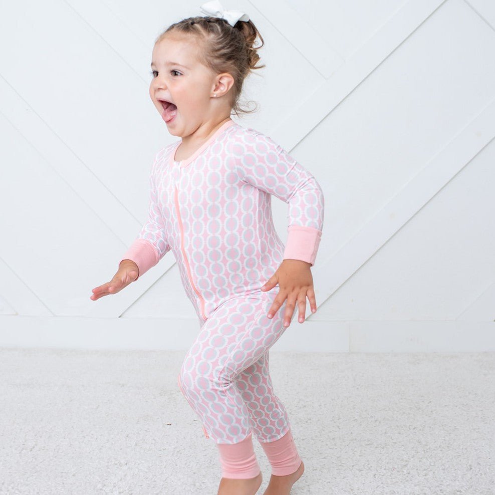 Baby convertible coverall in abstract pink cloud print with a full-length two-way zipper and fold-over feet.