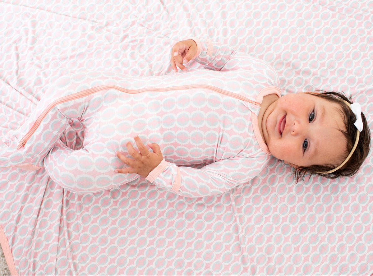 Baby footie pajamas in a pale lemonade clouds print with a full-length front zipper and covered feet.