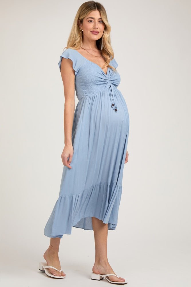 Pregnant model wearing a light blue smocked ruched ruffle hem maternity maxi dress