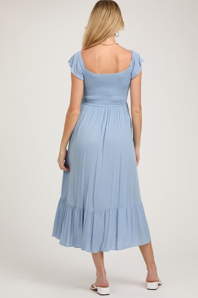 Pregnant model wearing a light blue smocked ruched ruffle hem maternity maxi dress