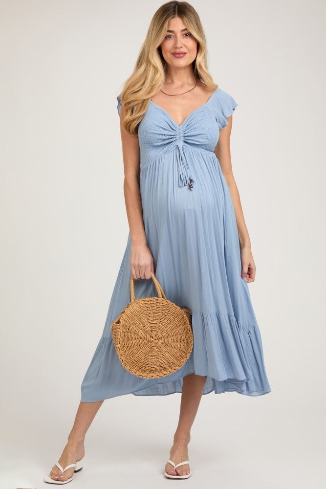 Pregnant model wearing a light blue smocked ruched ruffle hem maternity maxi dress