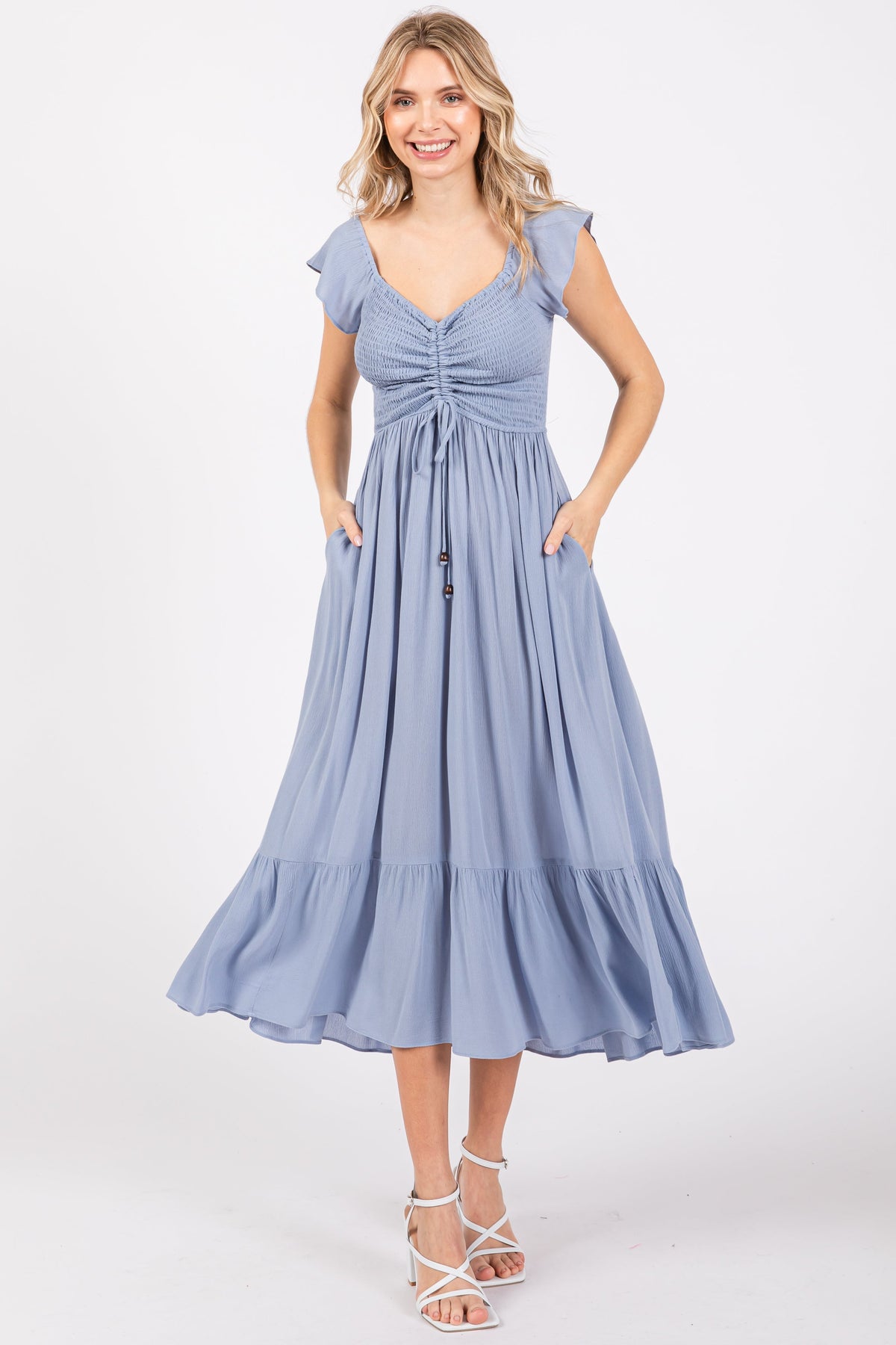 Pregnant model wearing a light blue smocked ruched ruffle hem maternity maxi dress