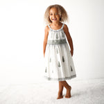 Cream baby girl dress with sage embroidery, lace hem, and an ombre effect, shown on a child model.