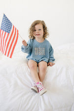 Baby wearing a cozy Little Joy Co. bamboo sweatshirt romper in a neutral color, smiling softly.