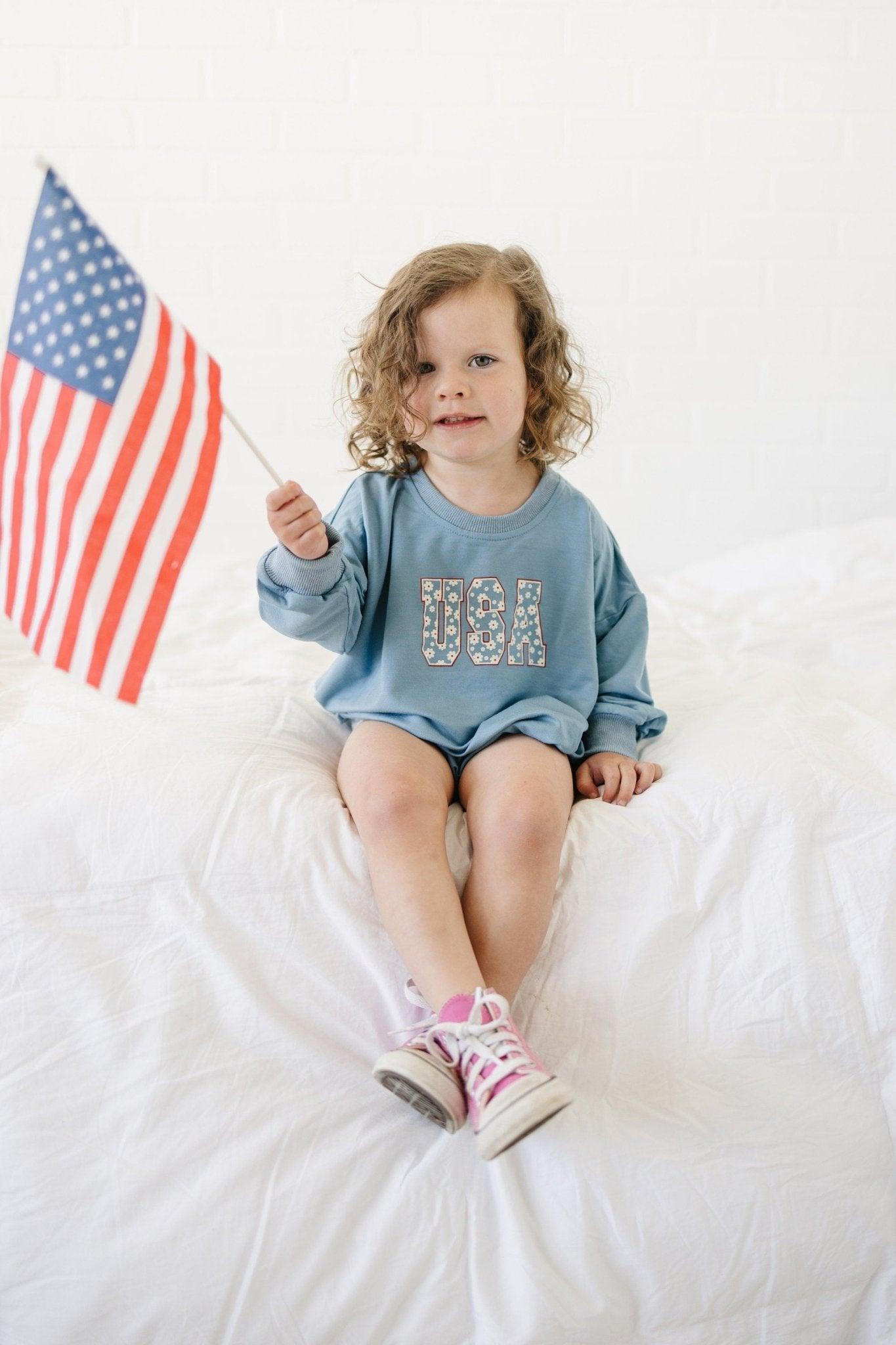 Baby wearing a cozy Little Joy Co. bamboo sweatshirt romper in a neutral color, smiling softly.