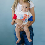 Little Joy Co. baby wearing a colorblock t-shirt romper with checkered flag and smile design