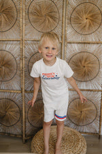 Toddler wearing a Little Joy Co. Organic USA Pride t-shirt, featuring a patriotic graphic.